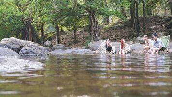 Group of Friends Relaxing in a River, People Enjoying Nature's Cool Waters, Young People Fun in a Shady Forest Stream photo