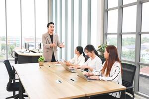 Professional Business Team Collaborating in Modern Office Meeting, Businessman Leading Discussion with Female Colleagues in Conference Room photo