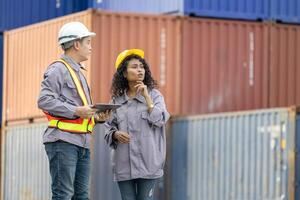 Engineers with tablet managing cargo operations, Engineer and foreman worker checking containers box at shipping yard photo