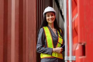 Female engineer managing cargo operations, Foreman dock worker checking containers box at shipping yard photo