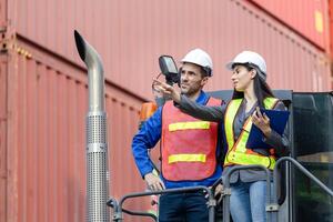 Engineer and foreman worker inspecting containers box at shipping yard, Inspectors standing on top of a container handlers machine at container yard photo