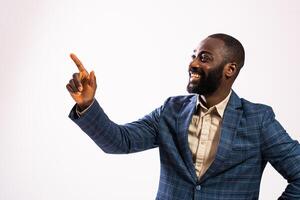 Handsome black businessperson with confident expression, pointing to empty gray background for your branding. photo