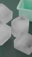 Ice cubes resting next to a tray on a table video