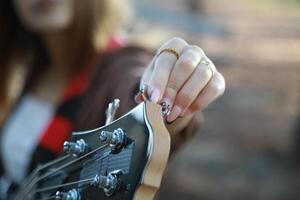 Girl Adjust Handles To Tune Bass Instrument In The Park photo