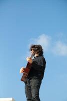 Man Plays Classical Guitar On A Day Stand In The Park Outdoor photo