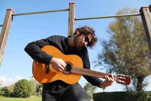 Man Classic Guitar Player Having Fun In The Park Outside photo