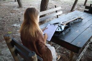 Girl Writes Music Notes On Sheet Music photo
