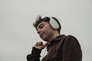 Man Relaxing On The Shore During Winter While Listening Music photo