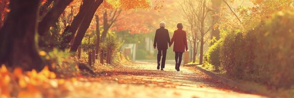 Elderly couple enjoys a serene autumn stroll hand in hand through a colorful forest path surrounded by falling leaves photo