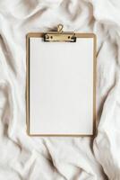 Blank clipboard on soft white fabric background for organizational and creative projects photo