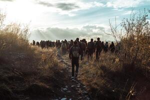 Seeking hope in the wilderness, a group of migrants journeys through barren land towards a better future photo
