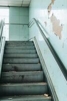 Broken escalator reflects transit challenges amidst decay in a public transport setting photo