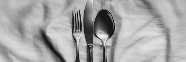 Plain silver cutlery displayed on textured cloth with elegant simplicity and minimalistic design photo