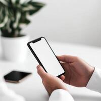 Person interacts with smartphone at a clean white desk with focus on technology and minimalism photo