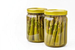Canned asparagus displayed in clear jars against a clean white background showcasing high quality and sharp details photo