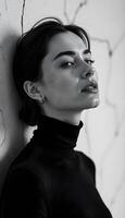 A woman in black and white posing against a wall photo