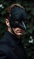 A man wearing a black bird mask photo
