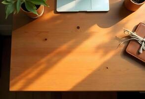 A laptop, notebook and a plant on a wooden desk photo