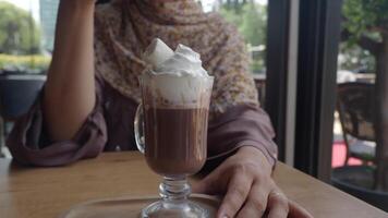 Enjoying hot chocolate topped with cream in a cafe video