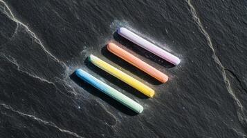 A group of four colored pencils on a black surface photo