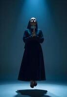 A nun standing in the dark with her hands on her knees photo