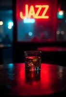 A glass of whiskey sits on a table in front of a jazz sign photo