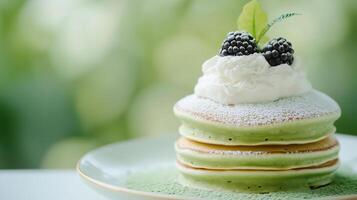 A stack of pancakes with green and blackberry toppings photo