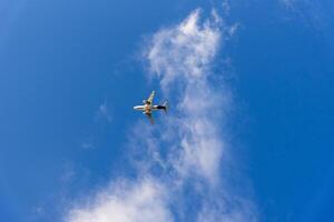 Plane flying outside on blue cloudy sky, air transport, sunny day, fluffy clouds photo