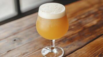 A glass of beer sitting on a wooden table photo