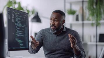 African american mature male in office environment discusses code on computer screen, displaying engagement and expertise in programming.. Mentor worker photo