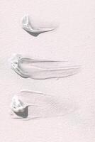 The texture of the cream on a light background. Translucent serum is smeared on the backdrop photo