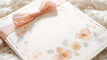Elegant floral invitation card with soft pastel colors, adorned with a delicate pink ribbon, resting on a cozy textured background, perfect for special occasions and celebrations photo