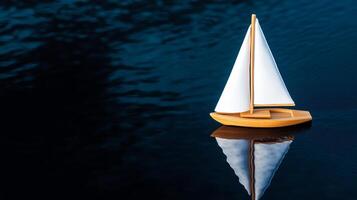 A small toy boat floating on a body of water photo