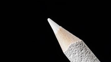 A close up of a white pencil on a black background photo