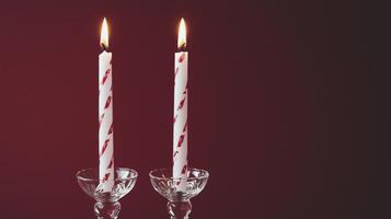 Two candles with white and red stripes on them photo