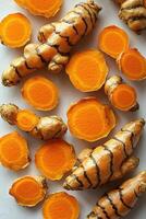 Turmeric roots and slices arranged on a white background photo