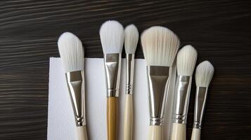 Five brushes are lined up on a napkin photo