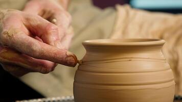 Close up potter using professional equipment man male master skill hobby art artcraft creating patterns clay pottery bowl jug vase craftsman small business workshop studio handwork handmade decoration video