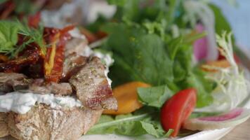 Fresh salad served with grilled meat on a wooden table video
