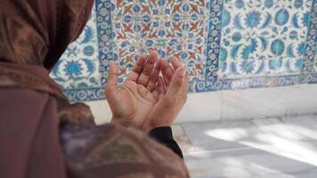 Praying hands at a historical site with ornate tiles video