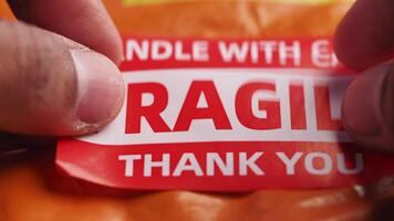 putting fragile label on a delivery packet video