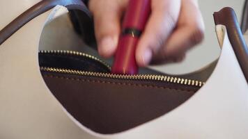 Woman organizes purse with beauty items in close-up video