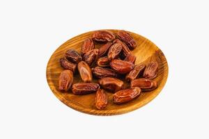 Delicious dried dates arranged on a wooden plate for serving photo