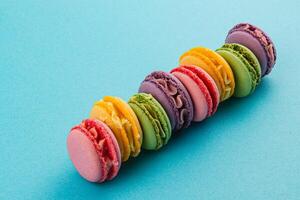 Colorful macarons lined up on a blue background photo
