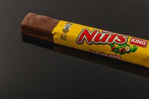 Lviv Ukraine 05.06.25 Chocolate bar with whole nuts on a black background photo