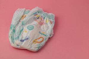 Lviv Ukraine 05.06.25 Diapers arranged on a pink background for baby care essentials photo