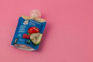 Lviv Ukraine 05.06.25 Fruit puree pouch with apple and pear on pink background photo