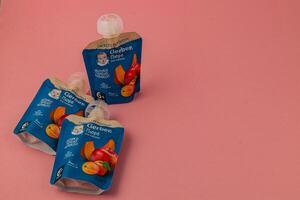 Lviv Ukraine 05.06.25 Baby fruit puree pouches on a pink background photo
