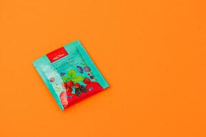 Lviv Ukraine 05.06.25 Colorful fruit-flavored candy packet on bright yellow background photo