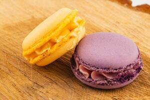 Colorful macaron pastries on a wooden board display photo